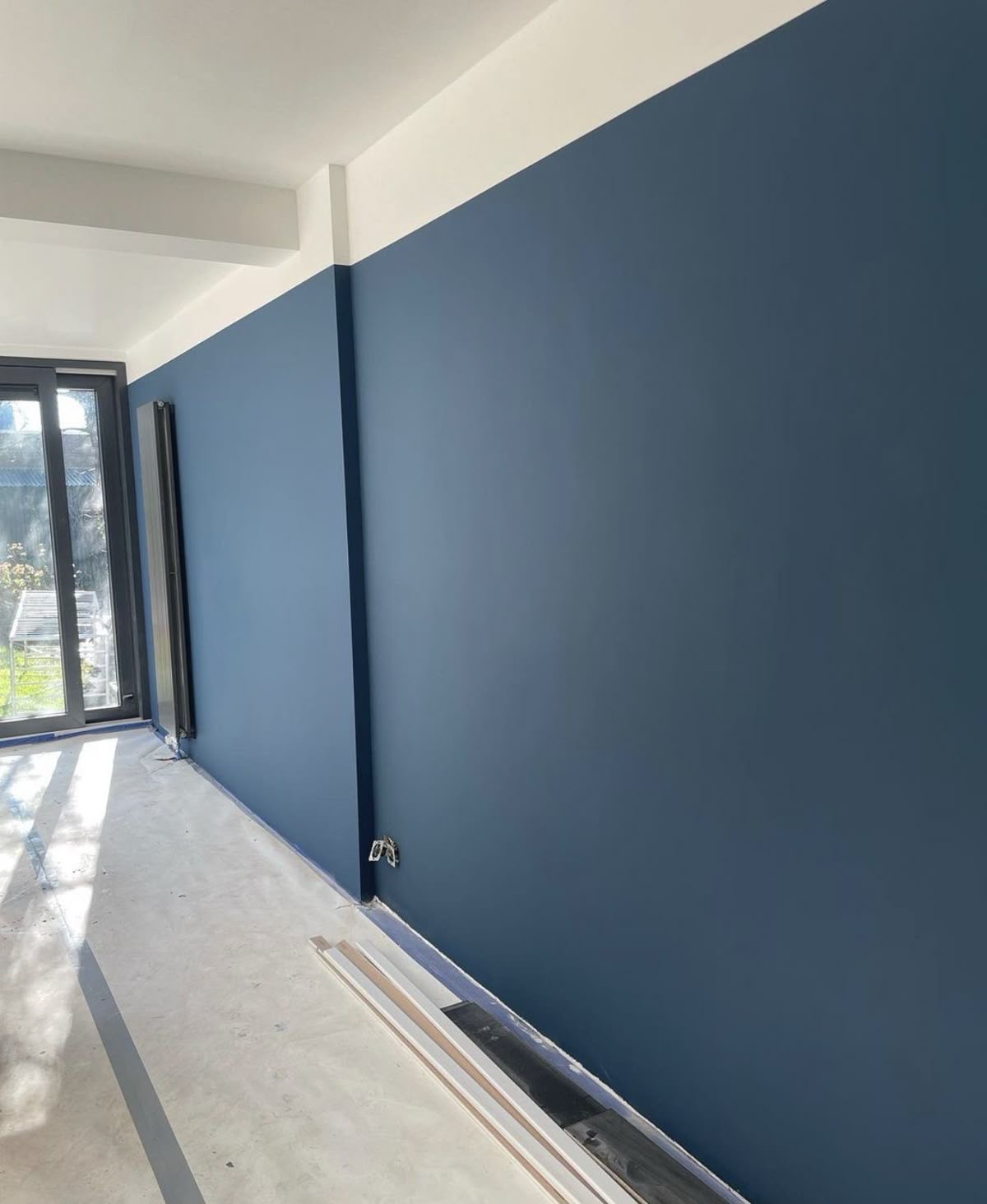 Strak gespoten diepblauwe wand met scherpe kantlijnen